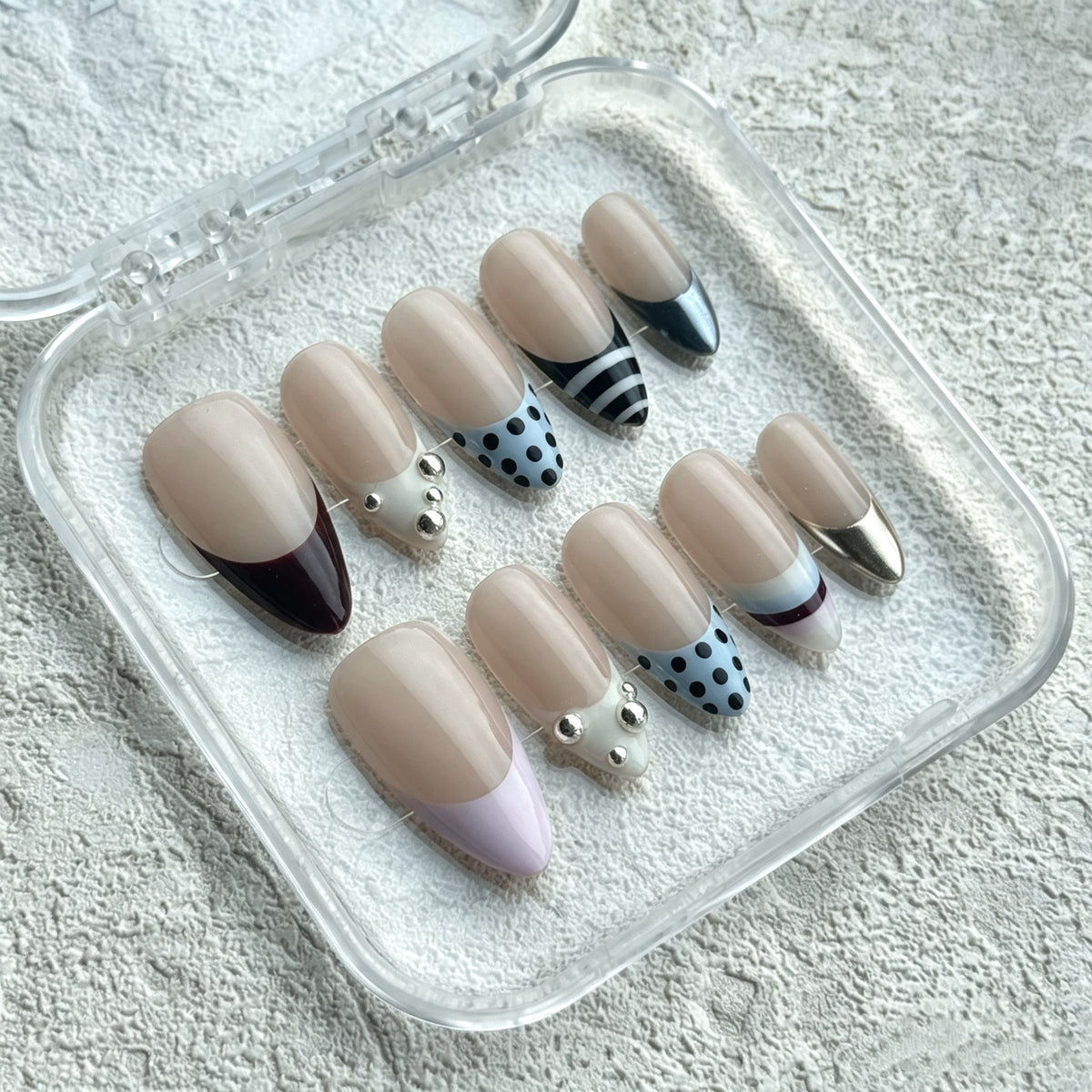 French Muse almond press-on nails with French tips, polka dots and gold accents