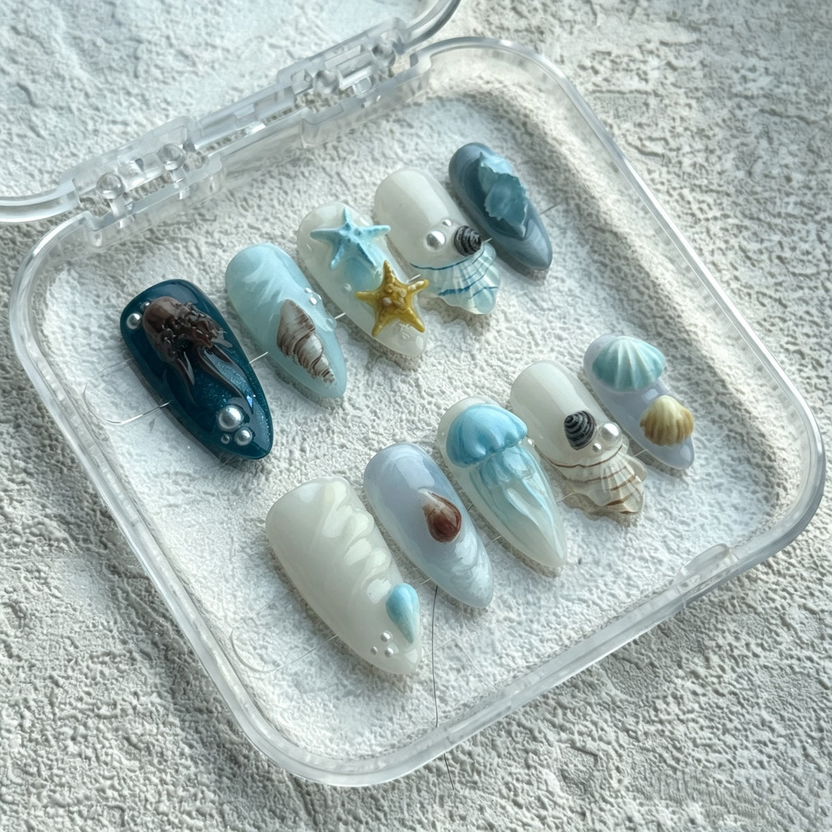 Ocean Muse blue almond press-on nails with 3D shell details and ocean-inspired accents